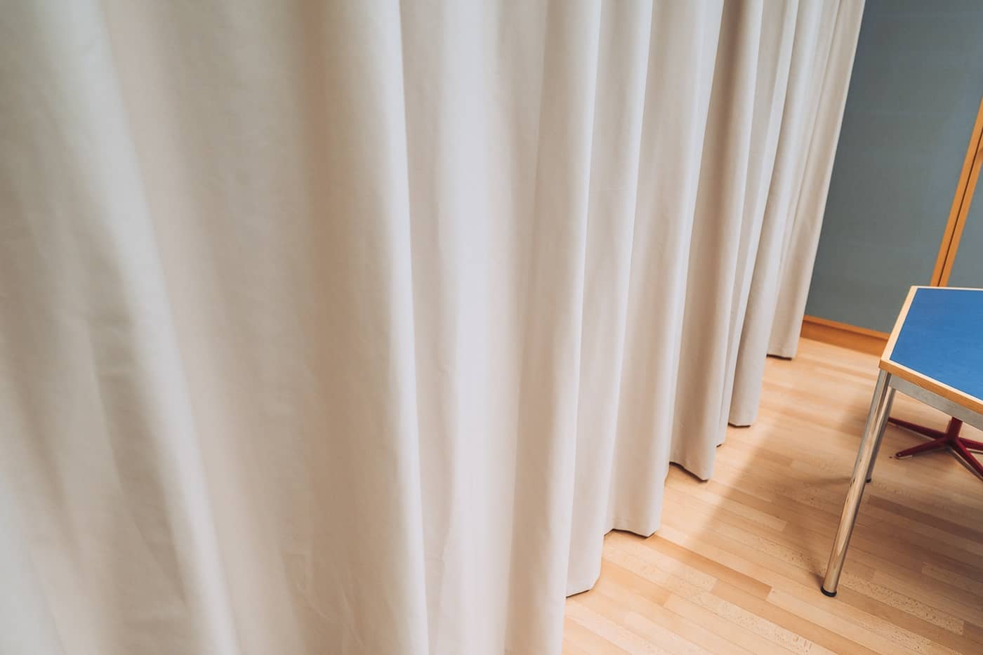 Detailansicht eines grauen, blickdichten Vorhangs, der von der Decke h&auml;ngt